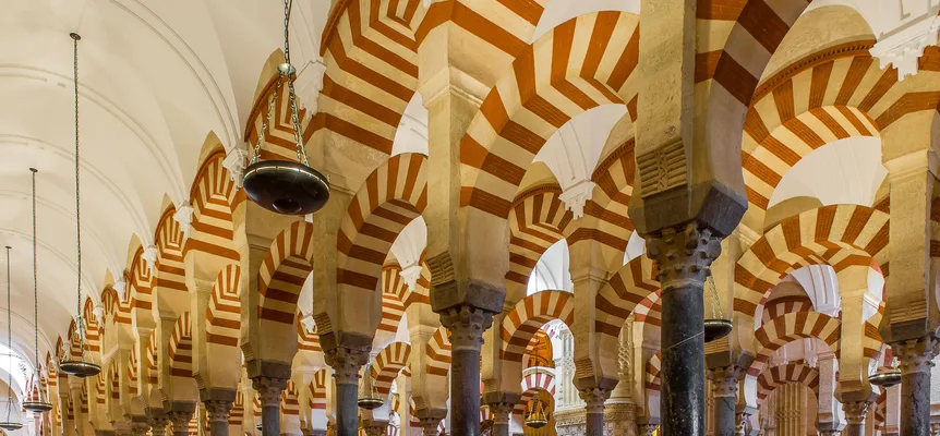 Rows of striped horseshoe arches inside the Mosque-Cathedral of Cordoba