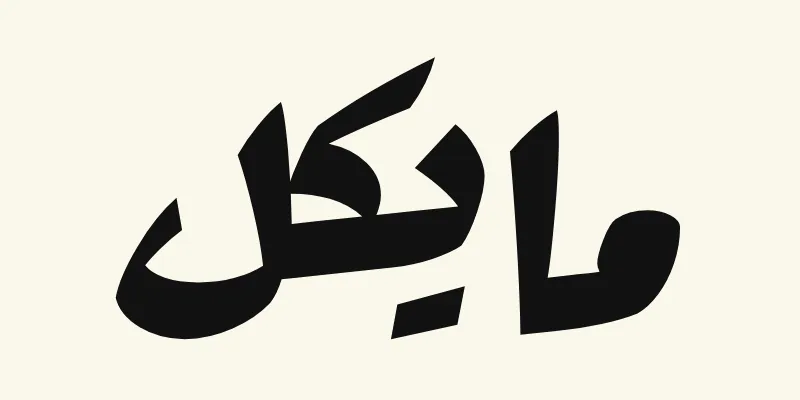 Der Name Michael auf Arabisch, مايكل, in schwarzer kräftiger Plakatschrift aus der Schriftart Rakkas auf cremefarbenem Hintergrund