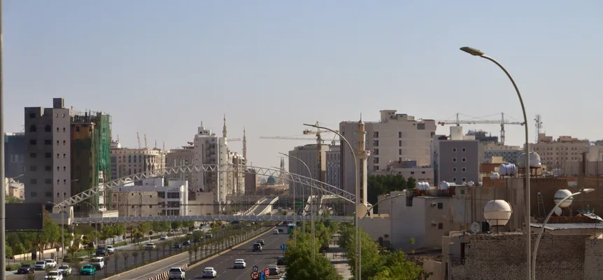 A busy Riyadh street with modern towers rising behind the traffic