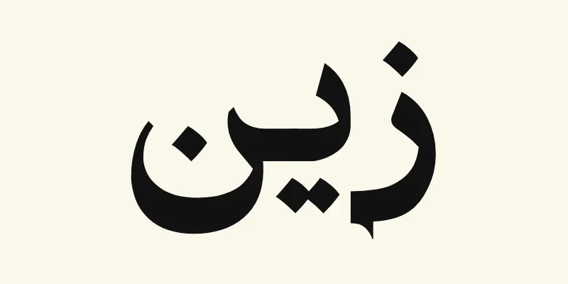 The name Zayn in Arabic, زين, in black headline lettering with small pointed outstrokes from the Katibeh font on a cream background